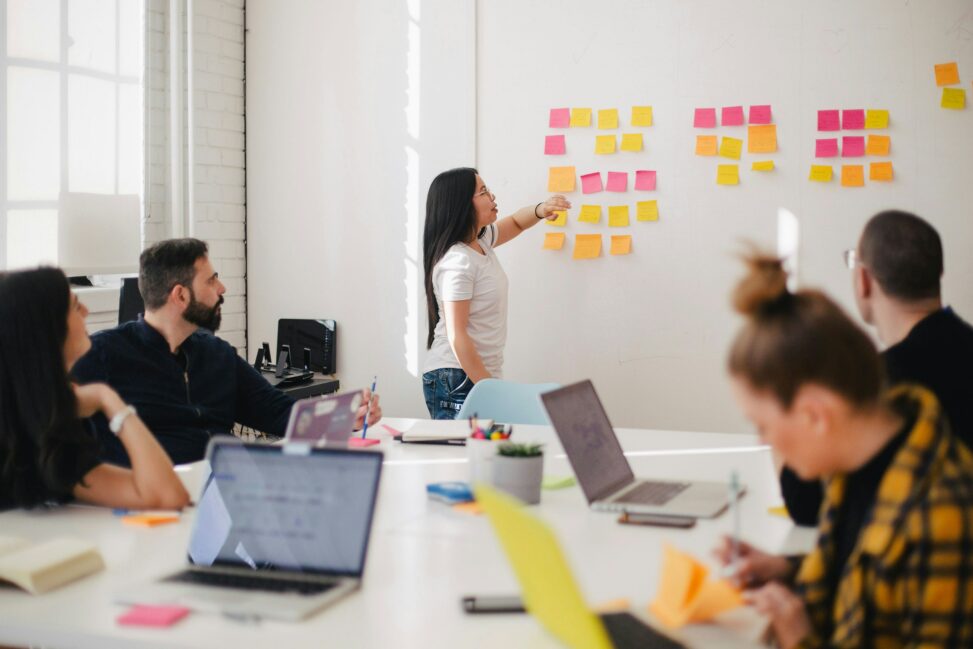 College classroom setting with a woman placing sticky notes on the wall